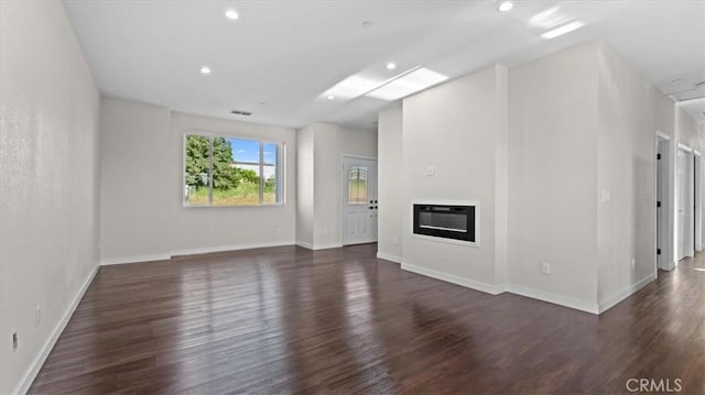 5627 Newland Rd, Paradise, CA 95969 - unfurnished living room with dark wood finished floors, a glass covered fireplace, baseboards, and recessed lighting