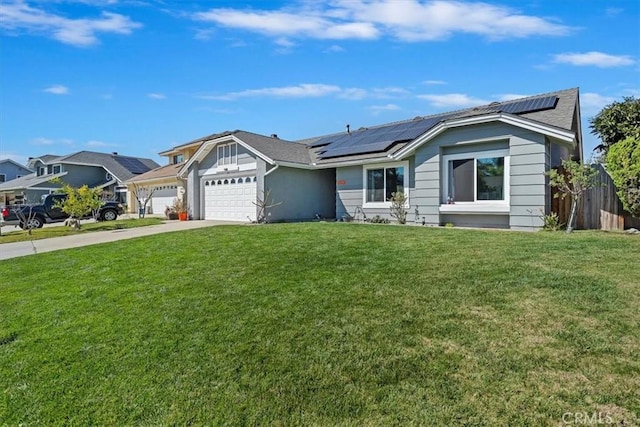 single story home with concrete driveway, a front yard, roof mounted solar panels, fence, and a garage