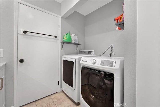 washroom with washing machine and dryer, laundry area, and light tile patterned flooring