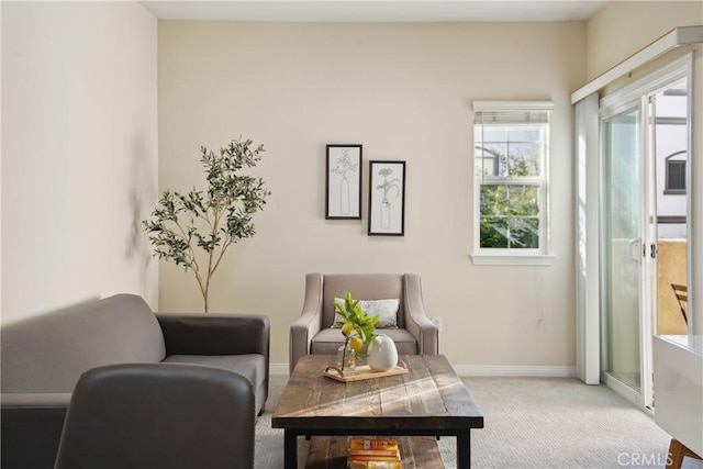 living area with light colored carpet and baseboards