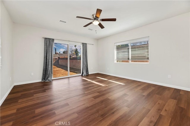 spare room with wood finished floors, visible vents, and a healthy amount of sunlight