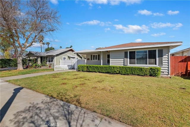 ranch-style home featuring a front yard, concrete driveway, and fence