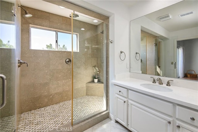 full bathroom featuring a stall shower, visible vents, and vanity