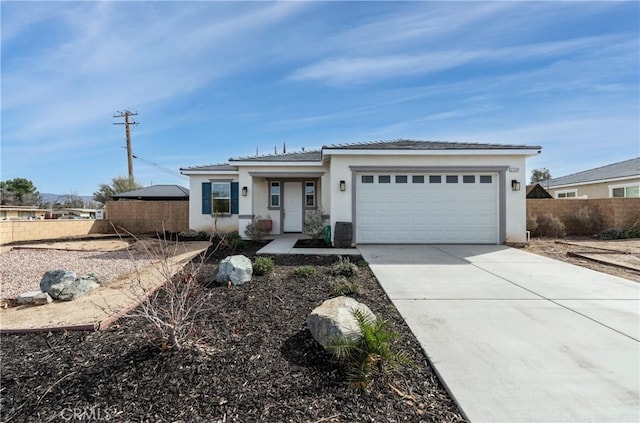 view of front of house with an attached garage, fence, concrete driveway, a tiled roof, and stucco siding