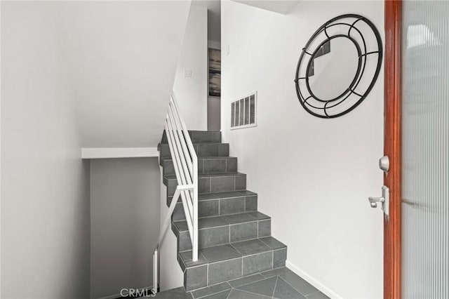 stairway featuring visible vents, baseboards, and tile patterned floors