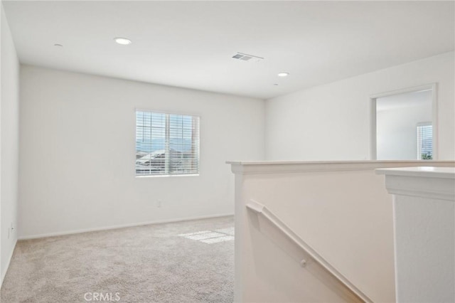 spare room featuring recessed lighting, visible vents, light carpet, and baseboards