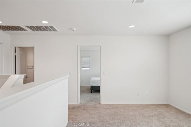 unfurnished room featuring light carpet, baseboards, visible vents, and recessed lighting