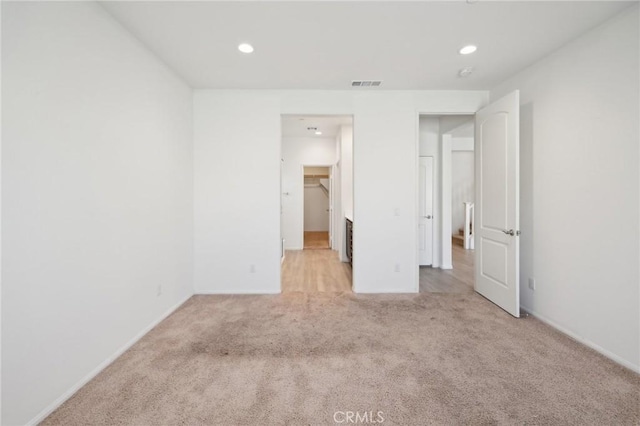 unfurnished bedroom featuring recessed lighting, visible vents, and light colored carpet