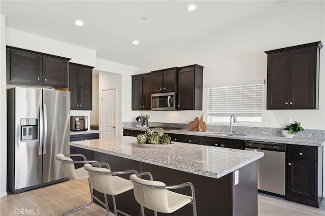 kitchen featuring a sink, stainless steel appliances, dark brown cabinets, and a kitchen island