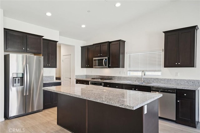 kitchen featuring a sink, stainless steel appliances, a kitchen island, and dark brown cabinetry