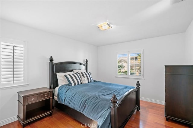 bedroom featuring wood finished floors and baseboards