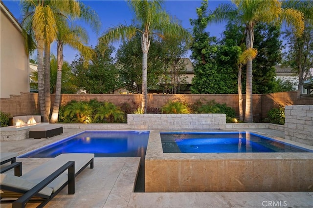 view of pool featuring a fire pit, an in ground hot tub, a patio, and a fenced backyard