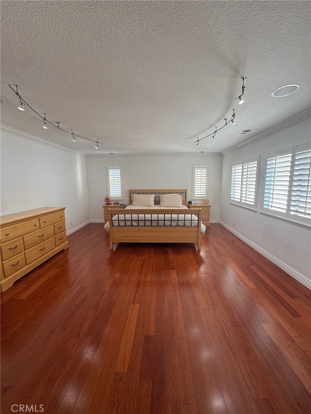 unfurnished bedroom with a textured ceiling, multiple windows, dark wood finished floors, and baseboards