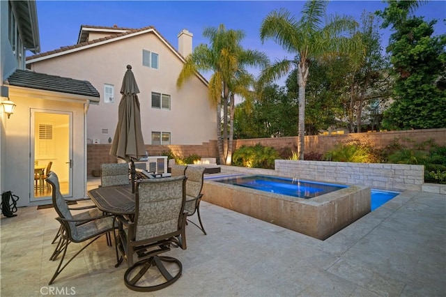 view of swimming pool featuring a patio area, outdoor dining area, a fenced backyard, and an in ground hot tub