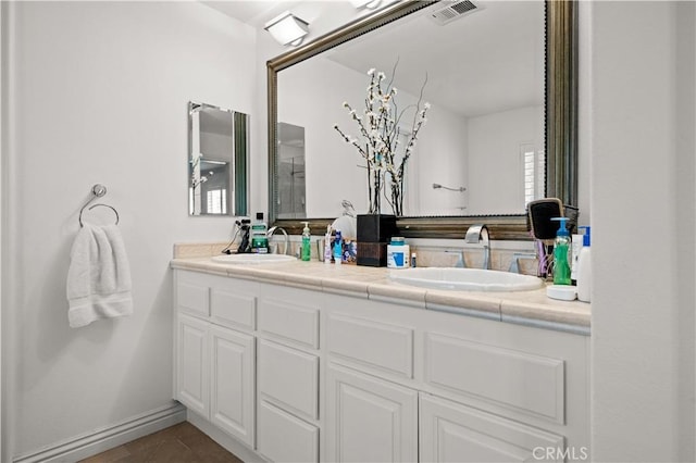 bathroom with double vanity, tile patterned flooring, a sink, and visible vents