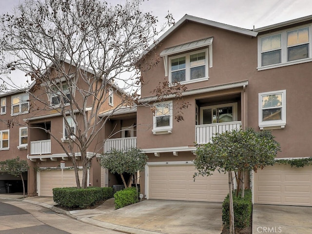 multi unit property with driveway, an attached garage, and stucco siding