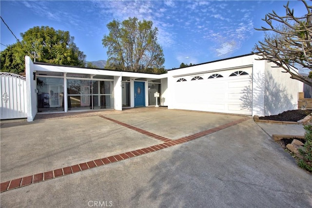 view of front of property with an attached garage, decorative driveway, and stucco siding