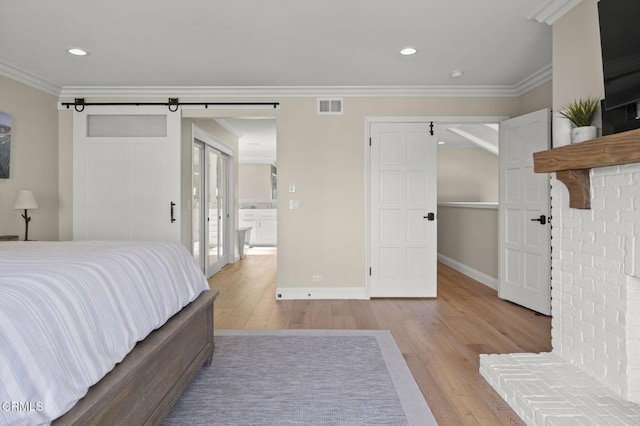 bedroom with ornamental molding, light wood-type flooring, visible vents, and baseboards