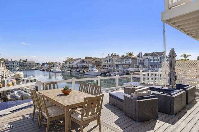 wooden deck with a residential view, a water view, outdoor dining space, and an outdoor hangout area