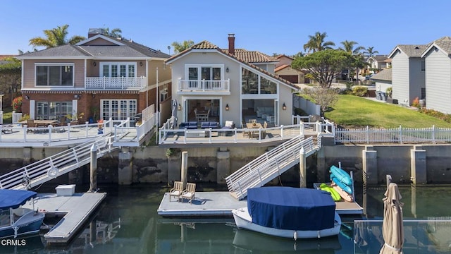 view of dock with stairway, a water view, and a balcony