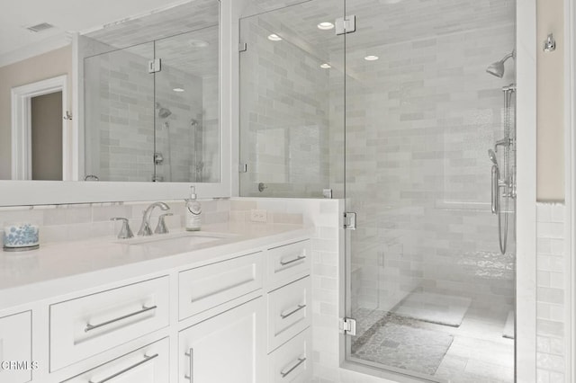 full bathroom featuring visible vents, a shower stall, and vanity