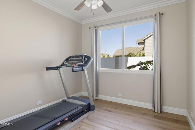 workout area featuring light wood-style floors, a ceiling fan, baseboards, and crown molding