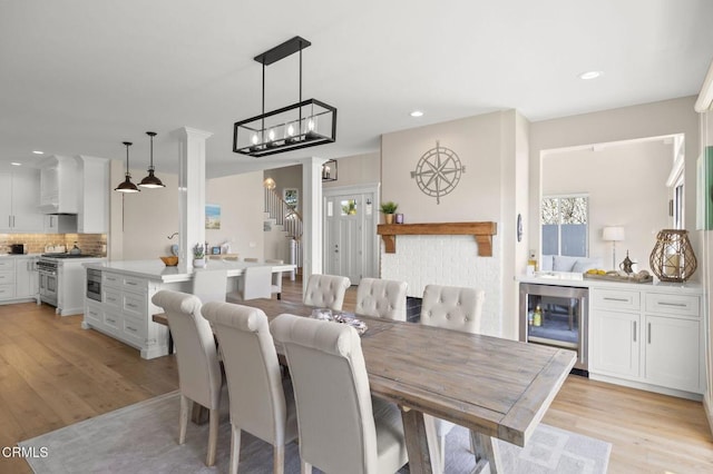 dining area featuring stairway, recessed lighting, beverage cooler, and light wood-style flooring