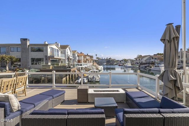 view of patio / terrace with a residential view, a water view, and a fire pit