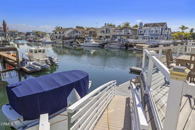 view of dock with a water view and a residential view