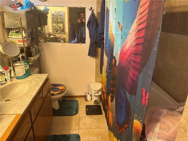 bathroom with baseboards, toilet, tile patterned flooring, shower / bath combination with curtain, and vanity