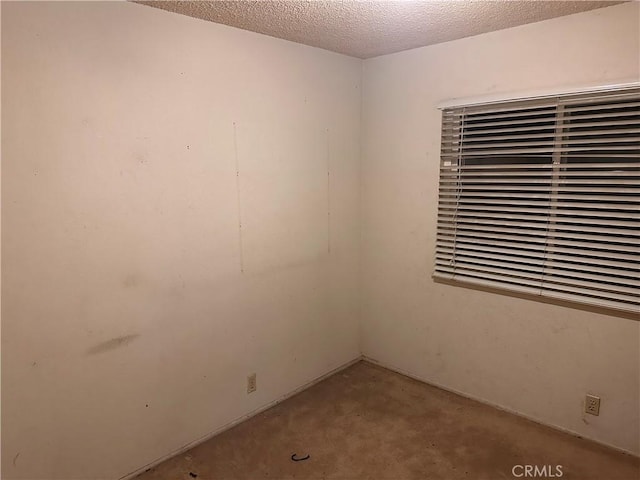 spare room featuring unfinished concrete flooring and a textured ceiling