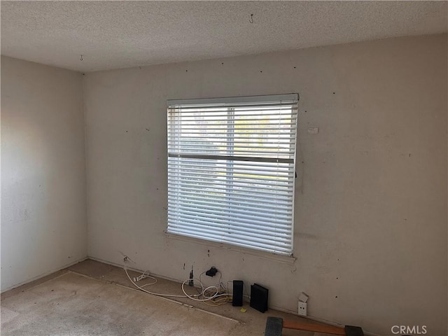 unfurnished room featuring a textured ceiling