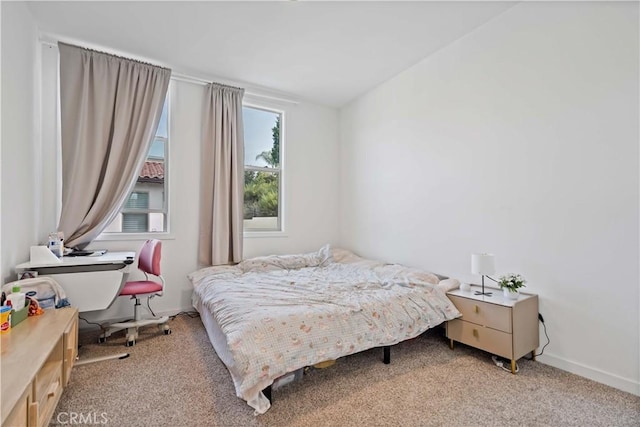 bedroom featuring light carpet and baseboards