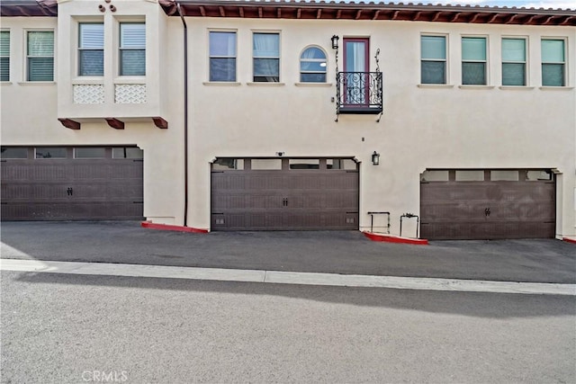 exterior space with an attached garage, driveway, and stucco siding