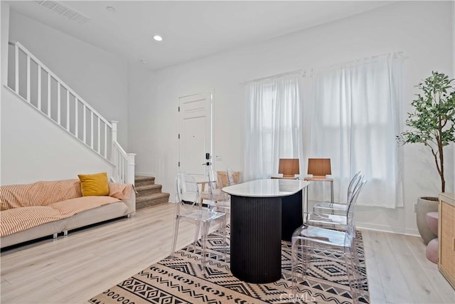 living area featuring light wood finished floors, plenty of natural light, stairway, and recessed lighting