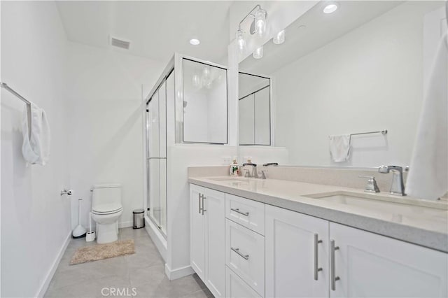 full bathroom with toilet, double vanity, a sink, and visible vents