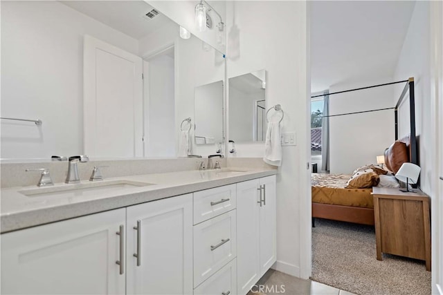 bathroom featuring double vanity, ensuite bath, visible vents, and a sink