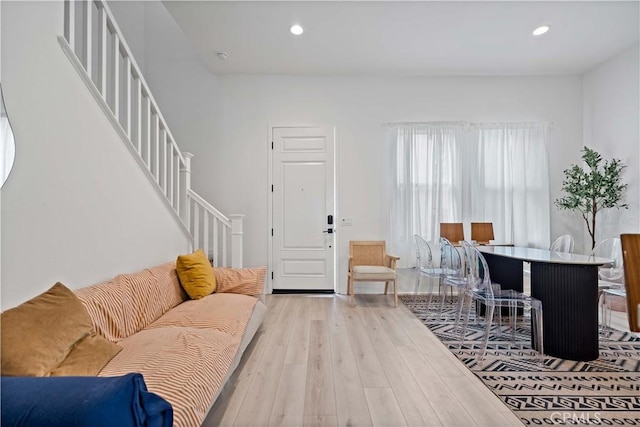 living area with light wood-style floors, recessed lighting, and stairway