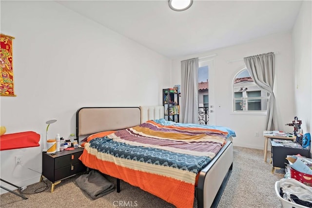 bedroom with baseboards and light colored carpet