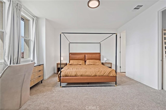 bedroom featuring visible vents, light carpet, and baseboards