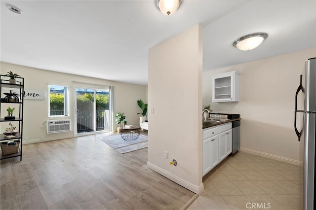 kitchen with dark countertops, appliances with stainless steel finishes, glass insert cabinets, and white cabinets