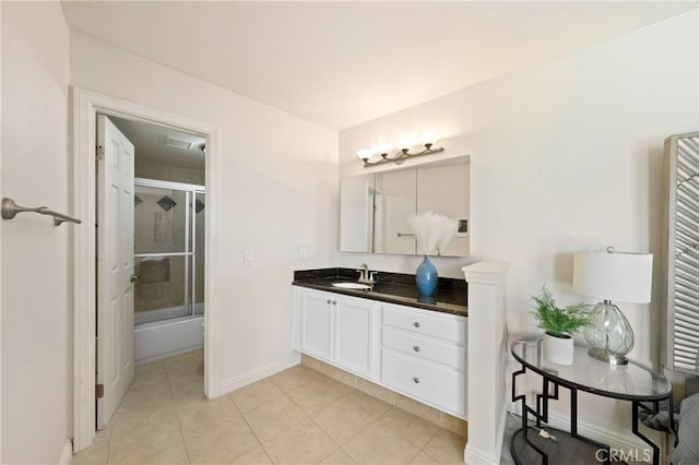 bathroom with baseboards, bath / shower combo with glass door, vanity, and tile patterned floors