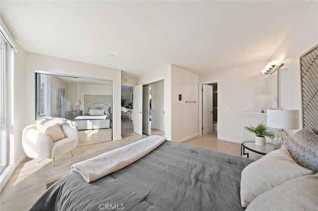 bedroom featuring light wood finished floors and baseboards