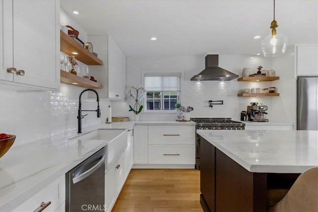 kitchen with appliances with stainless steel finishes, light wood-type flooring, wall chimney range hood, open shelves, and backsplash