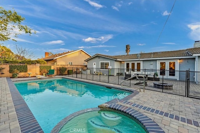 view of swimming pool with an outdoor fire pit, a patio, a fenced backyard, french doors, and a pool with connected hot tub