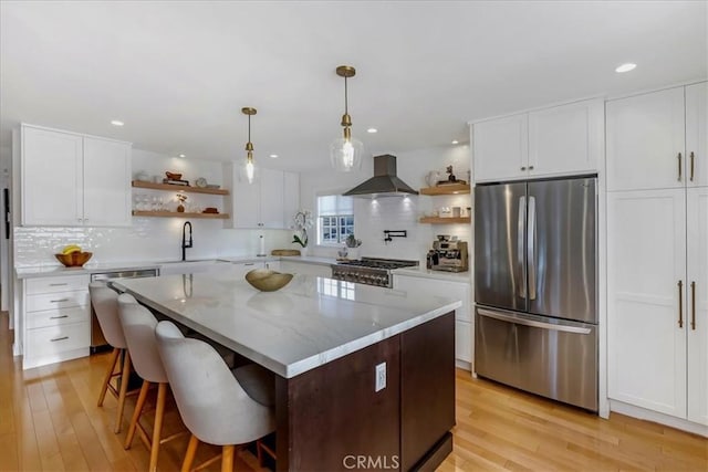 kitchen with open shelves, appliances with stainless steel finishes, a sink, and range hood