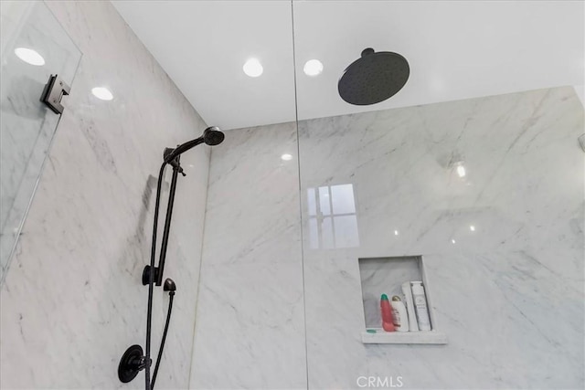 bathroom featuring a marble finish shower