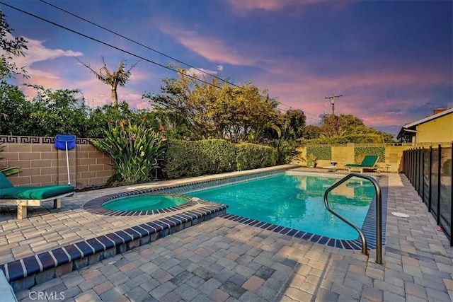 view of pool with a patio area, a fenced backyard, and a pool with connected hot tub