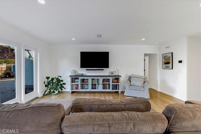 living room with visible vents, baseboards, wood finished floors, and recessed lighting