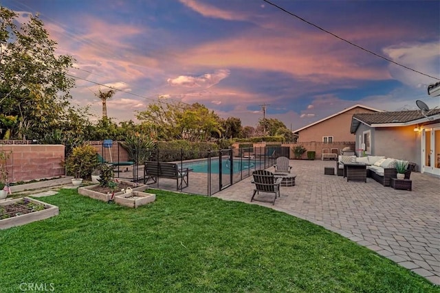 pool at dusk with a patio, a fenced backyard, an outdoor hangout area, a garden, and a lawn